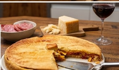Torta cortada servida com vinho e antepastos